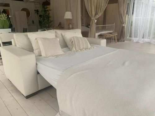a white bed with white sheets and pillows on it at Vakantiewoning Loft Lisse - SAUNA - Beach - Keukenhof in Lisse