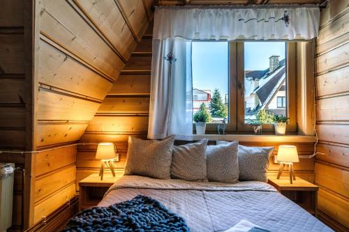 a bedroom with a bed and a window at Willa w Ubocy - "Jacuzzi i Sauna w ofercie dodatkowo płatnej" in Murzasichle