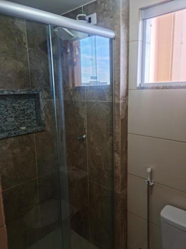 y baño con ducha y puerta de cristal. en Morro Vermelho en Goiânia