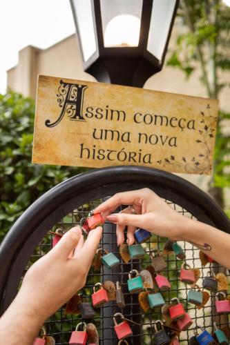 a woman is painting a piece of glass on a fence at Meliá Campinas in Campinas