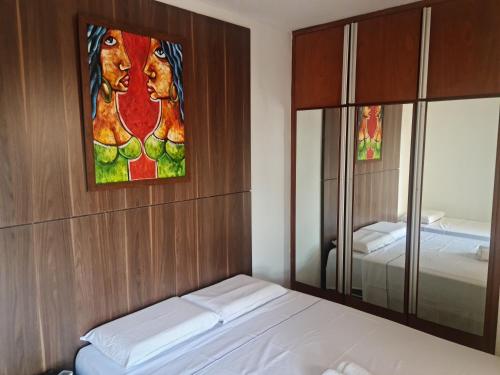 una camera da letto con un letto e un dipinto sul muro di Morro Vermelho a Goiânia