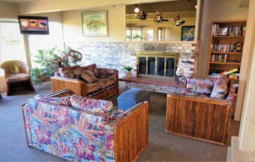 a living room with three couches and a fireplace at The Polynesian Resort in Ocean Shores