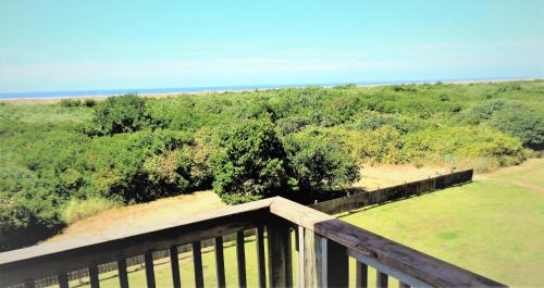 a balcony with a view of a field and trees at The Polynesian Resort in Ocean Shores