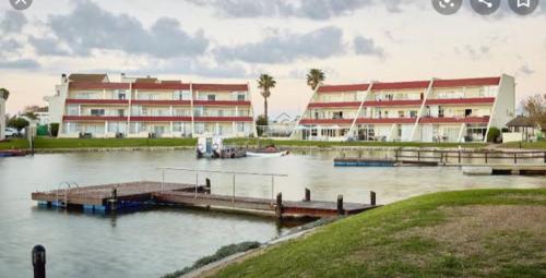 a large building with a dock and a boat in the water at la foi in Velddrif