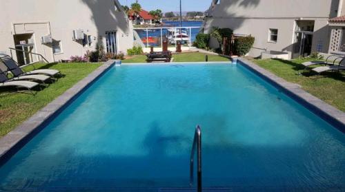 une grande piscine bleue en face d'une maison dans l'établissement la foi, à Velddrif