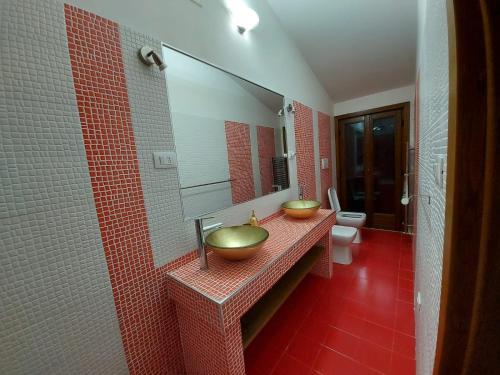 a bathroom with two sinks and a mirror at B&B Nonna Assunta in Collegiove