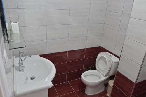 a bathroom with a white toilet and a sink at Mana Apartments in Ksamil