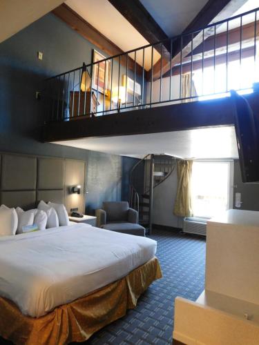 a hotel room with a bed and a staircase at Days Inn & Suites by Wyndham Downtown Gatlinburg Parkway in Gatlinburg