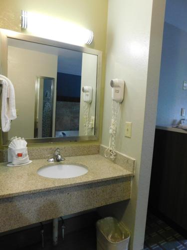 a bathroom with a sink and a mirror at Days Inn & Suites by Wyndham Downtown Gatlinburg Parkway in Gatlinburg