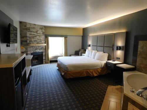 a hotel room with a large bed and a bathroom at Days Inn & Suites by Wyndham Downtown Gatlinburg Parkway in Gatlinburg