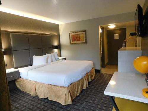 a hotel room with a large bed and a desk at Days Inn & Suites by Wyndham Downtown Gatlinburg Parkway in Gatlinburg