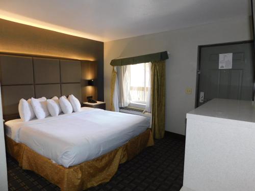 a hotel room with a large bed and a window at Days Inn & Suites by Wyndham Downtown Gatlinburg Parkway in Gatlinburg