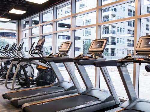 una fila de máquinas de entrenamiento cardiovascular en un gimnasio en Kimpton Tryon Park Hotel, an IHG Hotel en Charlotte