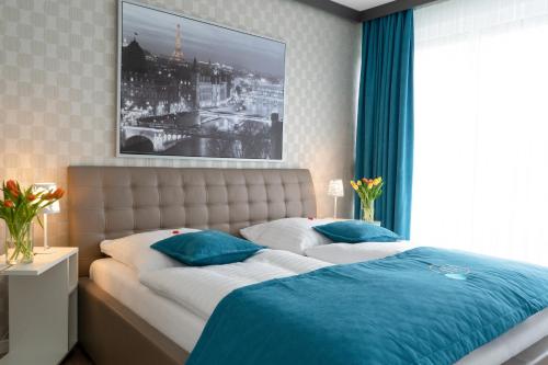 a bedroom with a large bed with blue pillows at Friends Hotel Bad Salzuflen in Bad Salzuflen
