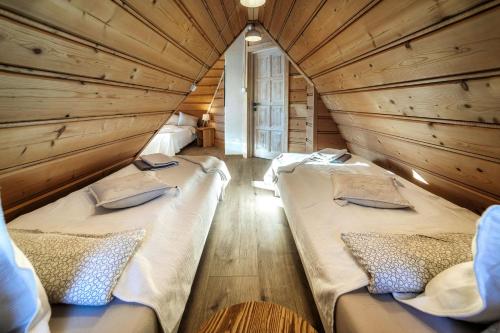 - 2 lits dans une chambre dotée de murs en bois dans l'établissement Willa w Ubocy - "Jacuzzi i Sauna w ofercie dodatkowo płatnej", à Murzasichle