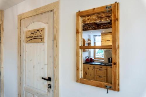 a mirror on a wall next to a kitchen at Willa w Ubocy - "Jacuzzi i Sauna w ofercie dodatkowo płatnej" in Murzasichle