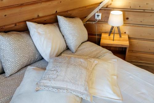 a bedroom with a bed with pillows and a lamp at Willa w Ubocy - "Jacuzzi i Sauna w ofercie dodatkowo płatnej" in Murzasichle