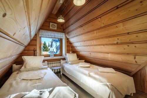a room with two beds in a log cabin at Willa w Ubocy - "Jacuzzi i Sauna w ofercie dodatkowo płatnej" in Murzasichle