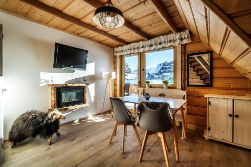a dining room with a table and chairs and a tv at Willa w Ubocy - "Jacuzzi i Sauna w ofercie dodatkowo płatnej" in Murzasichle