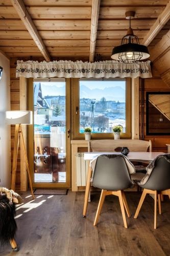 a dining room with a table and chairs and a window at Willa w Ubocy - "Jacuzzi i Sauna w ofercie dodatkowo płatnej" in Murzasichle