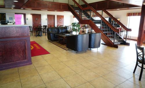 a restaurant with a bar with black chairs and stairs at Econo Lodge Inn & Suites in Kearney