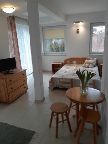 a bedroom with a bed and a table and chairs at Maris Pokoje Gościnne in Łeba