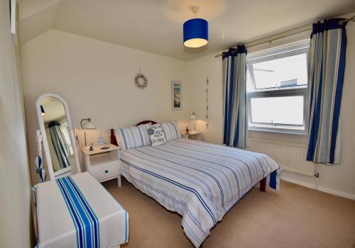 a bedroom with a bed and a mirror and a window at Boat House Sleeps 4 in the Centre of the Sailing Mecca of Cowes in Cowes