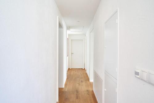 an empty hallway with white walls and wooden floors at Bergblick Acht Mondsee in Innerschwand am Mondsee