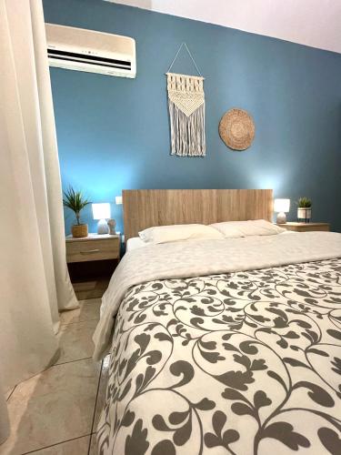 a bedroom with a bed and a blue wall at Anastasias house near Athens airport in Spáta