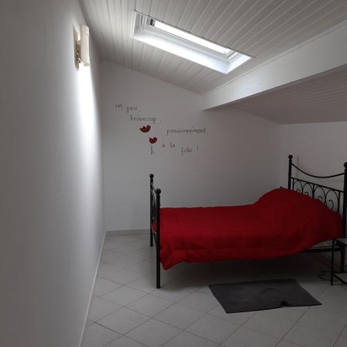 a bedroom with a red bed with writing on the wall at UR ONDOAN - Appartement Saint Pée sur Nivelle in Saint-Pée-sur-Nivelle