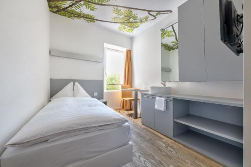 Schlafzimmer mit einem Bett und einem Spiegel in der Unterkunft Hôtel de la Poste Sierre in Sierre