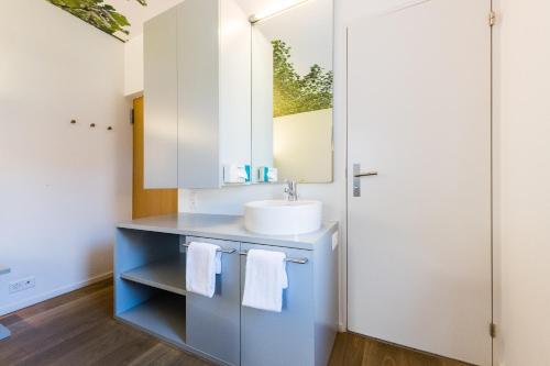 a bathroom with a sink and a mirror at Hôtel de la Poste Sierre in Sierre