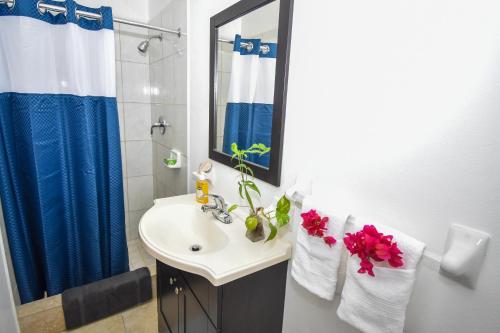 a bathroom with a sink and a blue shower curtain at Lord Nelson Hotel & Residences 