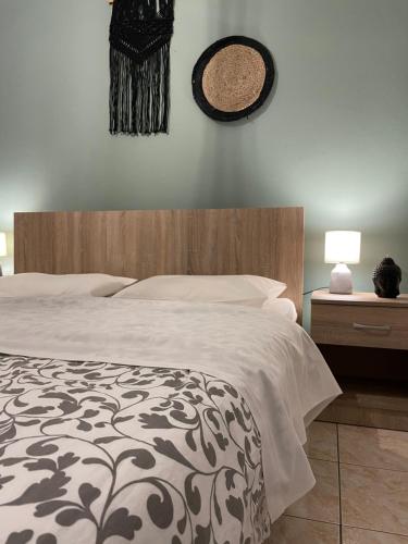 a bedroom with a bed and a clock on the wall at Anastasias house near Athens airport in Spáta