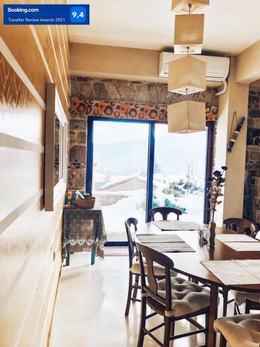 a restaurant with tables and chairs and a large window at studio Nick in Kalavrita
