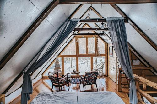 a bedroom with a bed and a table and chairs at Koliba Šume Pjevaju - robinzonski smjestaj, struja 12 V, voda iz cisterne in Mrkopalj