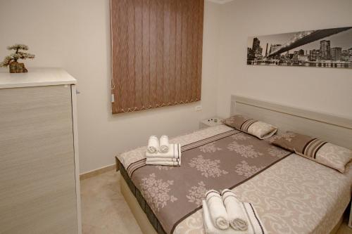 a bedroom with a bed with towels on it at Apartments Piano in Utjeha