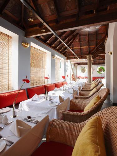 a dining room with white tables and chairs at Malabar House in Cochin