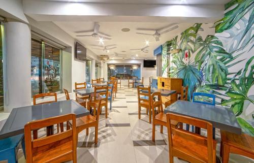 un restaurante con mesas y sillas y un mural en Hotel Posada De Roger, en Puerto Vallarta