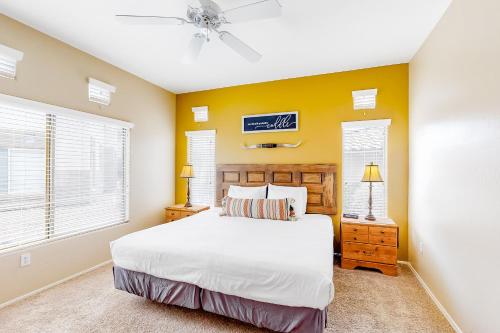 a bedroom with a white bed and yellow walls at Vistoso Resort Casita #163A in Tortolita