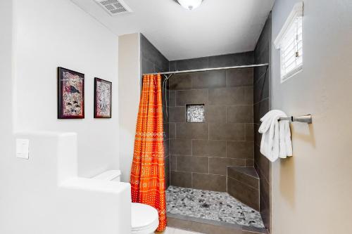 a bathroom with a shower with an orange shower curtain at Vistoso Resort Casita #163A in Tortolita