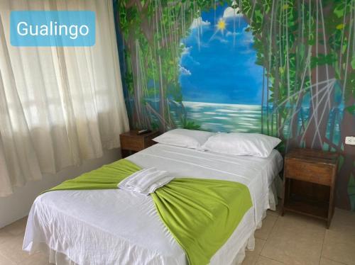 Schlafzimmer mit einem Bett mit Wandgemälde in der Unterkunft Hostal Gualingo in Santa Rosa