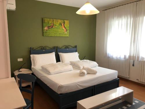 een slaapkamer met een bed met 2 kussens erop bij Fattoria Busa dell'Oro in Monte Ortone