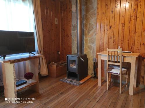 a living room with a wood stove and a tv at Hotel Último Paraíso in Cochrane