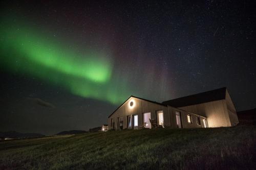 a building with the aurora in the sky at Apartment in the country, great view Apt. A in Akureyri