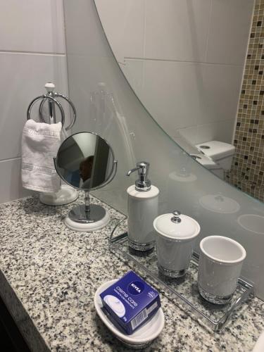 a bathroom with a counter with a sink and a mirror at Flat Vip 5 Estrelas Granja Vianna Moderno Sofisticado Alto Padrão Animália Park! in Cotia