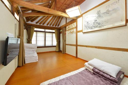 um quarto com uma cama e uma televisão em Dasomchae Hanok stay em Gwangju