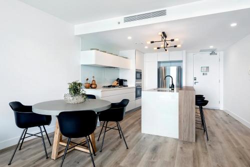 a kitchen and dining room with a table and chairs at Oracle Resort Broadbeach - gclr in Gold Coast