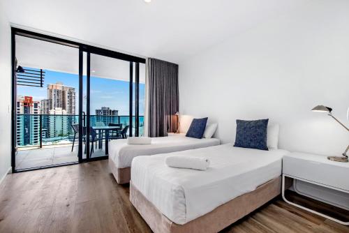 a hotel room with two beds and a balcony at Oracle Resort Broadbeach - gclr in Gold Coast