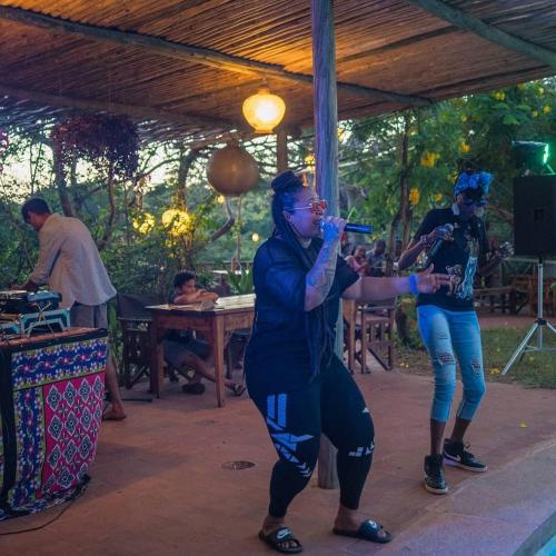 a group of people singing and dancing at a party at Distant Relatives Ecolodge & Backpackers in Kilifi
